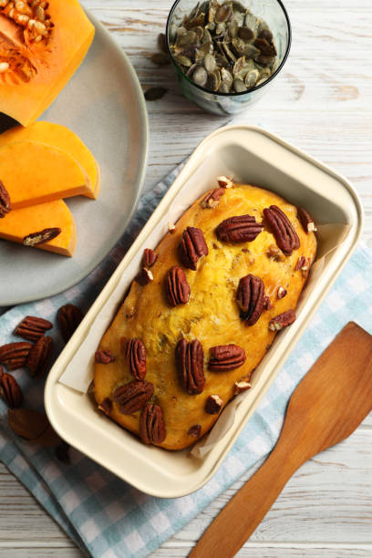 pão de abóbora delicioso com nozes de pecan na mesa de madeira clara, flat lay - healthy eating cake halloween seed - fotografias e filmes do acervo