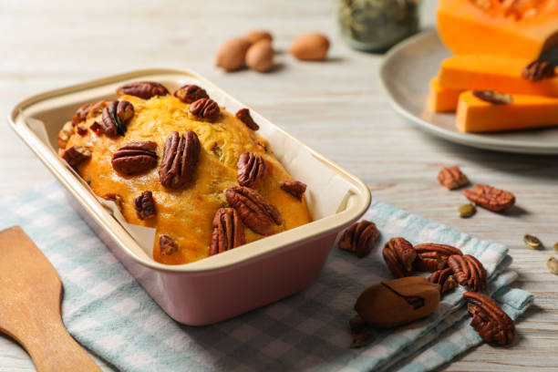 pão de abóbora delicioso com nozes de pecan na mesa de madeira clara - healthy eating cake halloween seed - fotografias e filmes do acervo