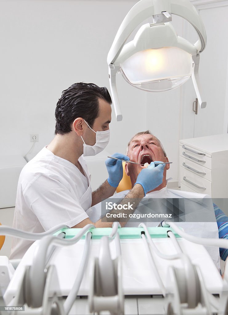 Dental inspection "Dentist holding dental instruments in senior man's mouth, close up" Examining Stock Photo