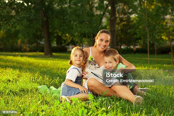 Madre Con Figlia E Figlio Leggere Un Libro Aperto - Fotografie stock e altre immagini di 6-7 anni - 6-7 anni, Abbigliamento casual, Adulto