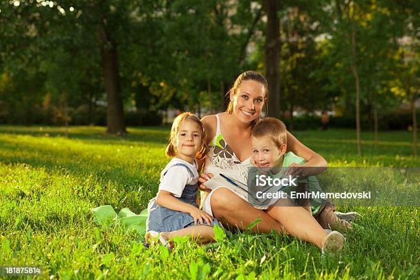 Mãe Com A Filha E Filho Ler Um Livro Ao Ar Livre - Fotografias de stock e mais imagens de 6-7 Anos - 6-7 Anos, Adulto, Alegria