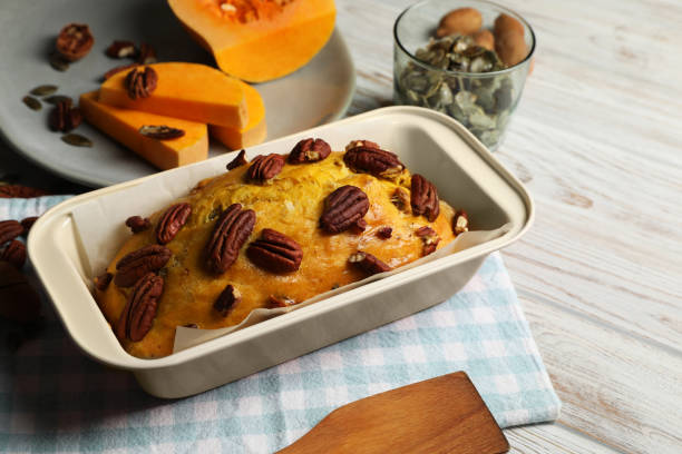 pão de abóbora delicioso com nozes de pecan na mesa de madeira clara - healthy eating cake halloween seed - fotografias e filmes do acervo