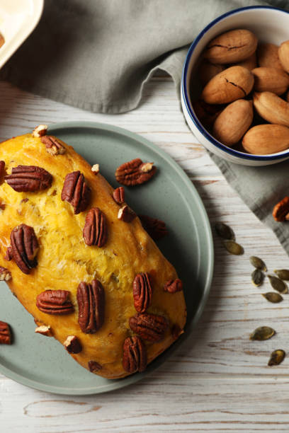 delizioso pane di zucca con noci pecan su tavolo di legno chiaro, lay piatto - healthy eating cake halloween seed foto e immagini stock