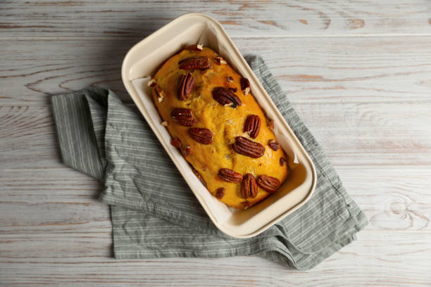 delizioso pane alla zucca con noci pecan su tavolo in legno chiaro, vista dall'alto - healthy eating cake halloween seed foto e immagini stock