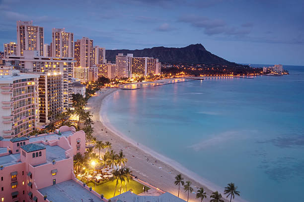 Waikiki at dusk The quintessential view of Waikiki, Hawaii -- luxury hotels, the beach, and Diamond Head. night view on honolulu city and waikiki beach stock pictures, royalty-free photos & images