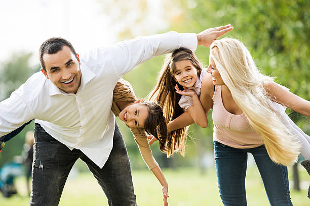 istock Mother and father piggybacking their daughters. 181876277