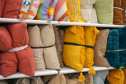 beautiful pillows cushions on shelf at textile store for sale
