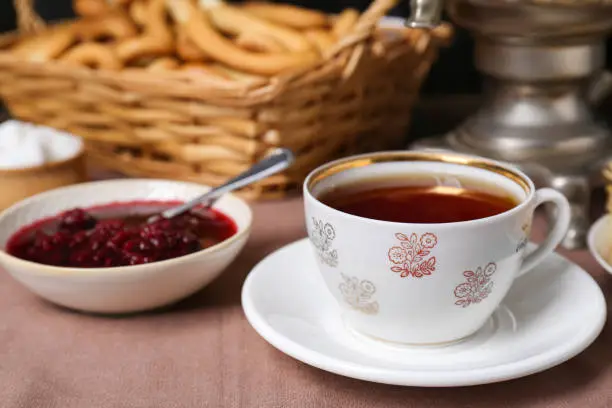 Aromatic tea and cherry jam on table, closeup. Space for text