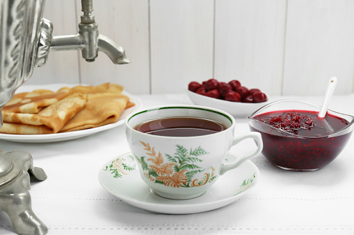 Cup of aromatic tea and treats on table