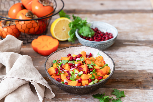 Persimmon Salsa. Healthy vegetarian bowl salad with Persimmon, pomegranate, cucumber, onion and cilantro.