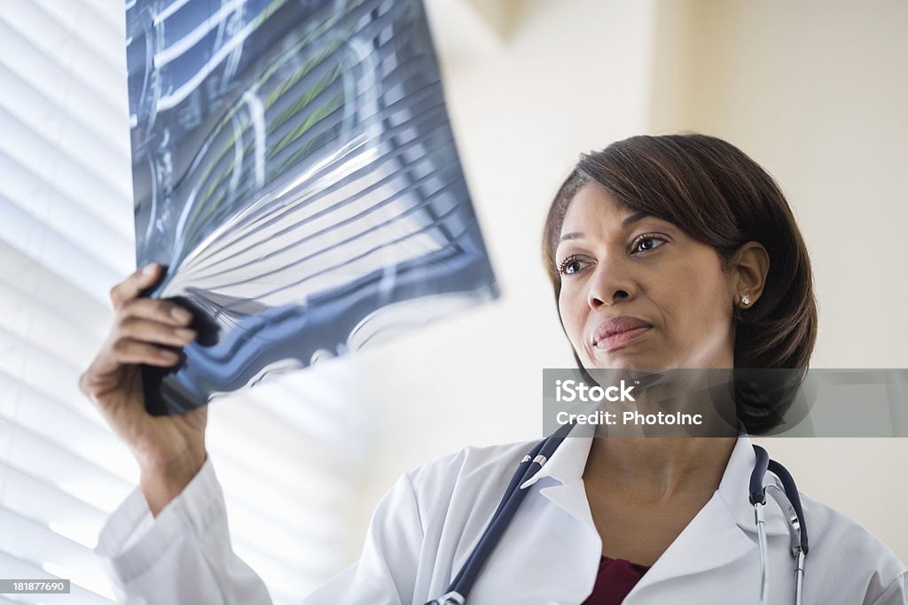 Feminino médico examinando raios X no Hospital relatório - Foto de stock de 30 Anos royalty-free