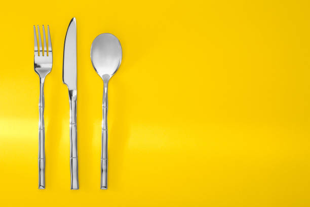 istock Spoon, fork and knife on yellow background, flat lay. Space for text 1818777743