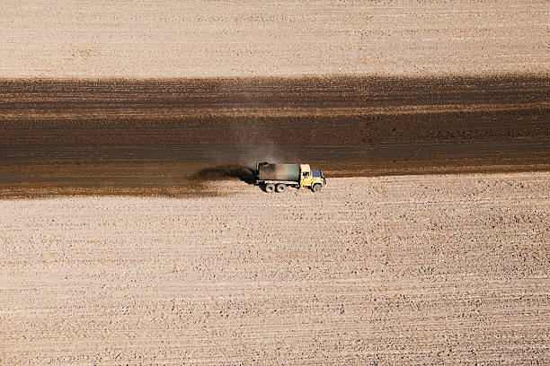 Manure Spreading on Harvested Cornfield Aerial Aerial view of a tank truck spreading manure on a recently harvested corn field. The manure acts as an organic fertilizer for next seasonaas crop. Shot from the open window of a small plane. apply fertilizer stock pictures, royalty-free photos & images