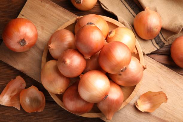 istock Many ripe onions on wooden table, flat lay 1818787368