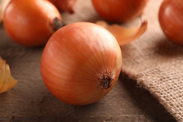 istock Many ripe onions on wooden table, closeup 1818787955