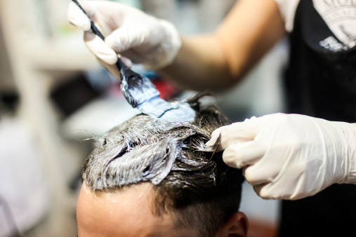 Man in a hair salon coloring hair