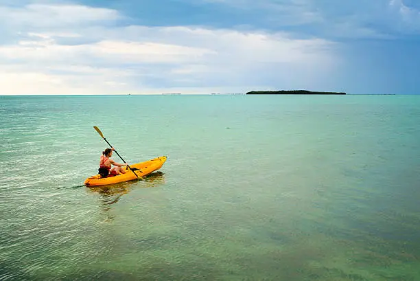 A woman kayaking in the Florida Keys on a stormy day.