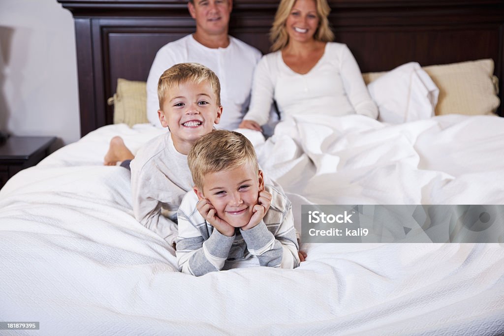Dwóch chłopców, leżąc na łóżku rodziców w tle - Zbiór zdjęć royalty-free (30-39 lat)