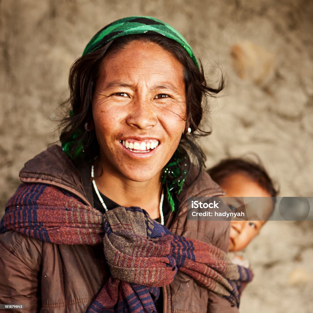 Tibetan mother carrying her child "Mustang region is the former Kingdom of Lo and now part of Nepal,  in the north-central part of that country, bordering the People's Republic of China on the Tibetan plateau between the Nepalese provinces of Dolpo and Manang. The Kingdom of Lo, the traditional Mustang region, and aUpper Mustangai are one and the same, comprising the northern two-thirds of the present-day Nepalese Mustang District, and are well marked by official aMustangai border signs just north of Kagbeni where a police post checks permits for non-Nepalese seeking to enter the region, and at Gyu La (pass) east of Kagbeni." Nepal Stock Photo