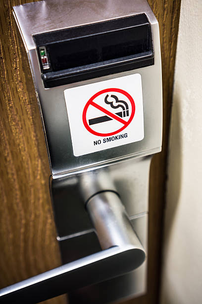 No Smoking Sign on Hotel Room Door Lock No smoking sign on a hotel room electronic door lock handle. Picture is high resolution and vertical. nonsmoker stock pictures, royalty-free photos & images