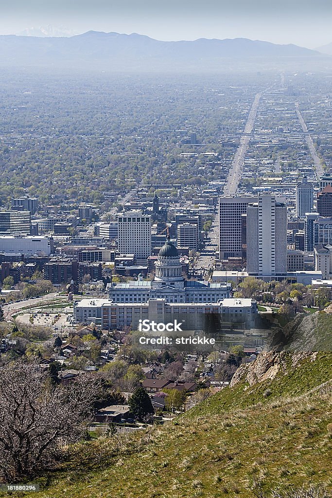 Salt Lake City from Foothills North of Downtown, Vertical "Skyline of Salt Lake City, Utah, USA in early spring from a vantage point high above the state capitol building north of downtown. Prominent is the Utah State Capitol Building and the downtown district with State Street and Main Street leading south along the Salt Lake Valley floor. Also: religious buildings of Temple Square including:  the Salt Lake temple of the Church of Jesus Christ of Latter-day Saints, the Joseph Smith Building (formerly the Hotel Utah), and the administrative office building of the Church of Jesus Christ of Latter-day Saints. Also: the Eagle Gate Building, bank high rise buildings, and apartment condominiums. In the distance, smog clouds the floor of the Salt Lake Valley.RELATED IMAGES" Air Pollution Stock Photo