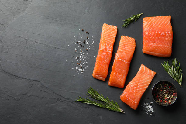 istock Fresh raw salmon and spices on black table, flat lay. Space for text 1818805082