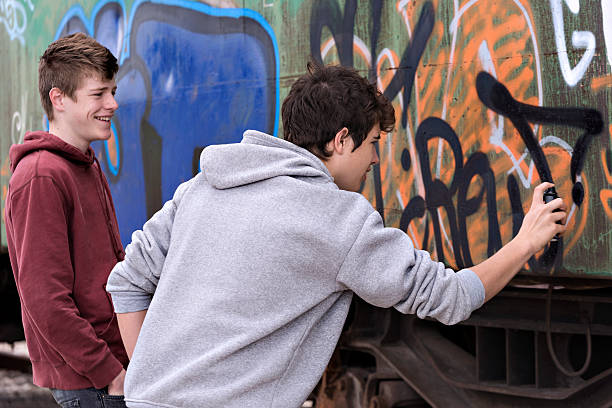 Graffiti Two young painting graffiti on an old  wagon train vandalism stock pictures, royalty-free photos & images