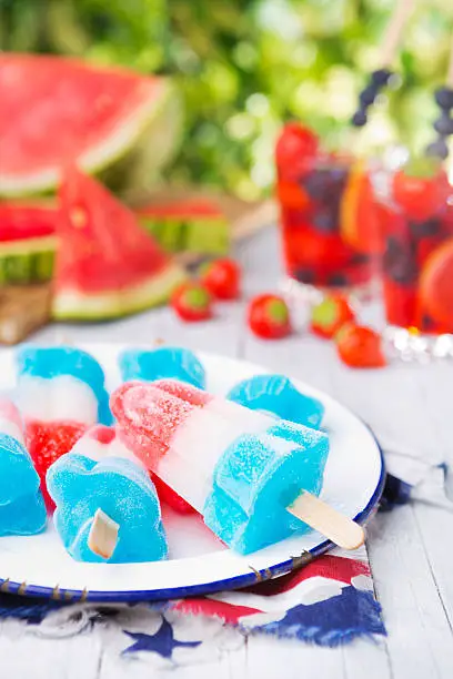 Homemade red-white-and-blue popsicles on an outdoor table.