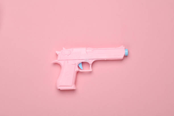 istock Plastic pistol on a pink background. Minimalism 1818826387