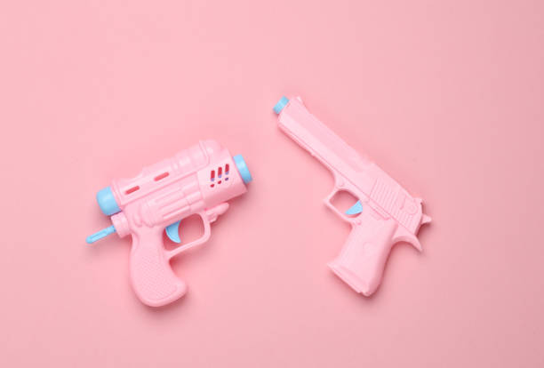 istock Two Plastic pistols on a pink background. Minimalism 1818826391