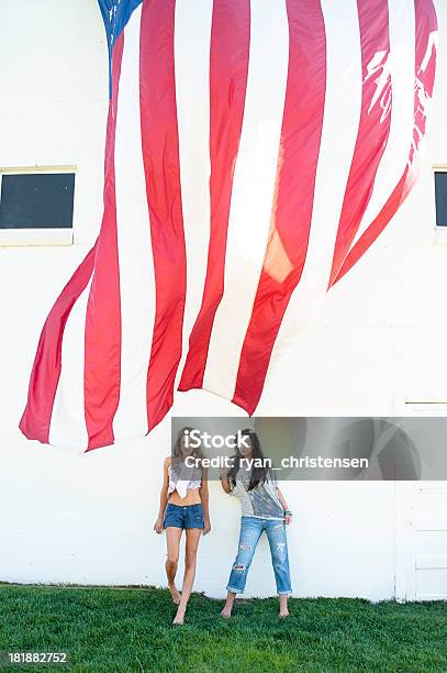 Bela Jovem Mulher Em Pé Em Uma Bandeira Americana Contra A Parede - Fotografias de stock e mais imagens de 20-29 Anos
