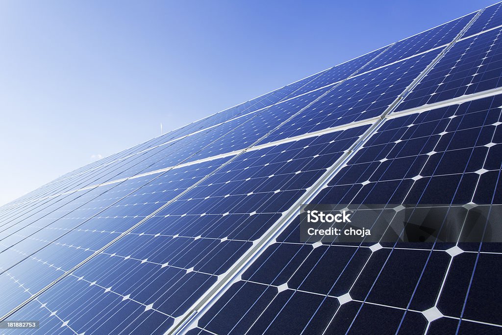 Painéis solares em um dia ensolarado contra o céu azul límpido - Foto de stock de Eletricidade royalty-free