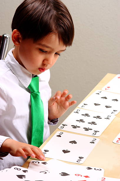 istock Little Boy Playing Cards At Table 181884446