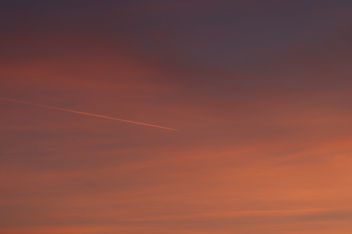 A Red Sky with an airplane and clouds