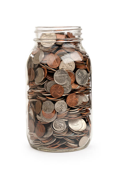 Coin Jar Jar full of coins, isolated on white.Please also see: coin jar stock pictures, royalty-free photos & images