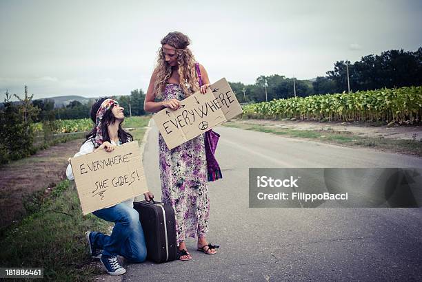 Young Adult Hippie Couple Hitchhiking With Placards In Hand Stock Photo - Download Image Now