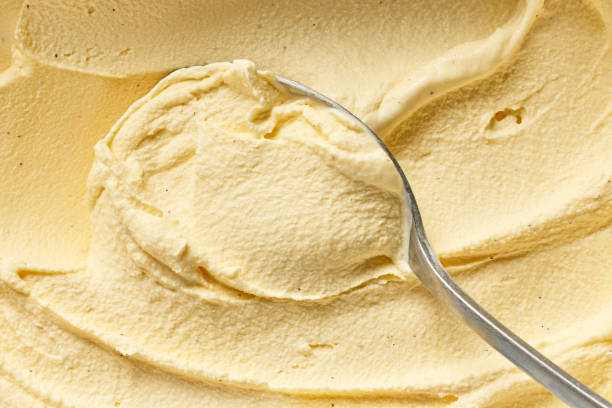 homemade vanilla ice cream homemade vanilla and banana ice cream in a spoon peach color table stock pictures, royalty-free photos & images