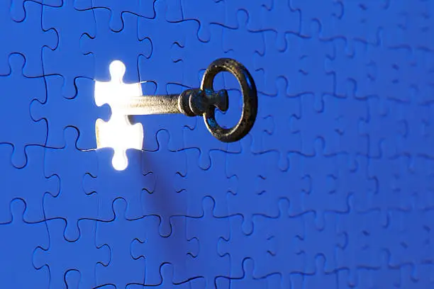 Photo of Inserting an antique skeleton key in a blue jigsaw puzzle