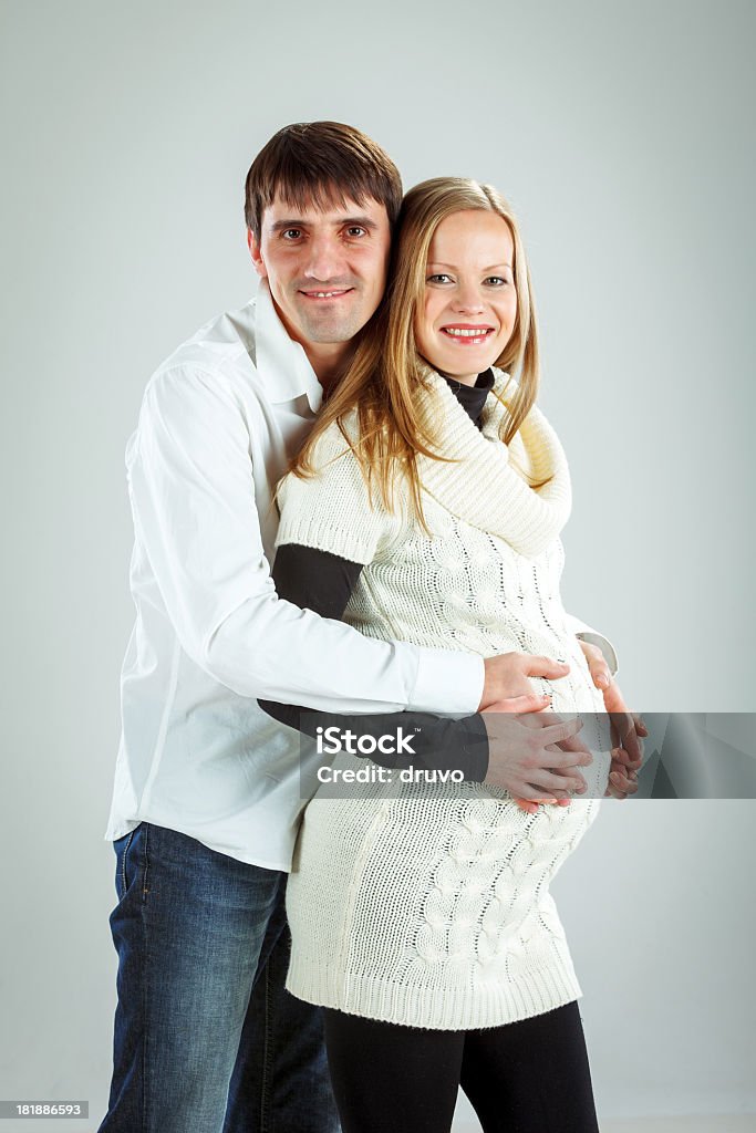 Giovane Coppia in attesa di un bambino - Foto stock royalty-free di Abbracciare una persona