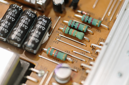 The inner circuit board of an old and outdated VCR are examined on a coffee table.