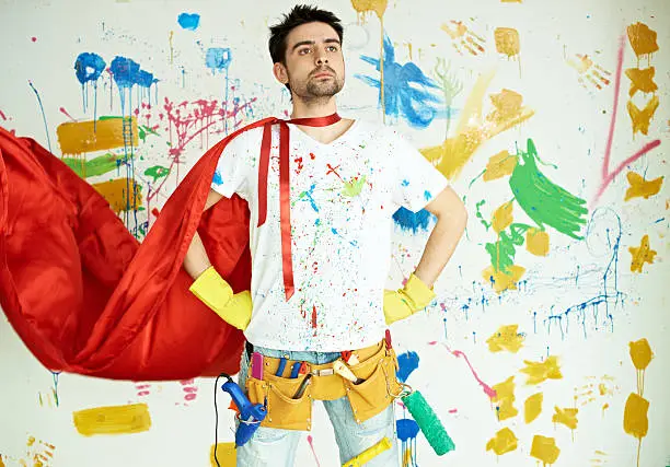 Super house painter posing in front of colorful wall