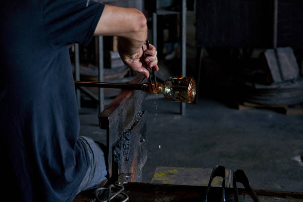 istock Crop man making glass using rod and tongs in workshop 1818869322