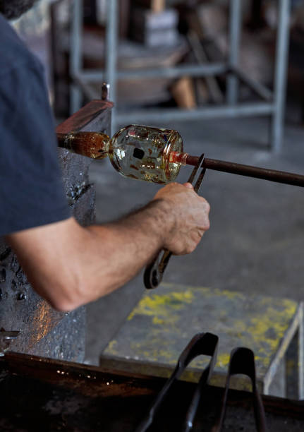 istock Crop glassblower shaping hot glass in workshop 1818873635