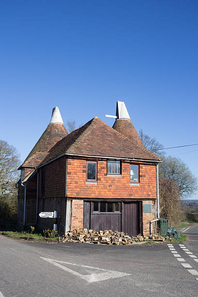 Oast House in Chiddingstone, England An oast house or hop kiln in Chiddingstone. These buildings are designed for drying or kilning hops in the due course of brewing. Some oasts are converted into residential structures. oast house farmhouse village lane stock pictures, royalty-free photos & images