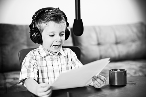 Little boy playing radio newscaster.