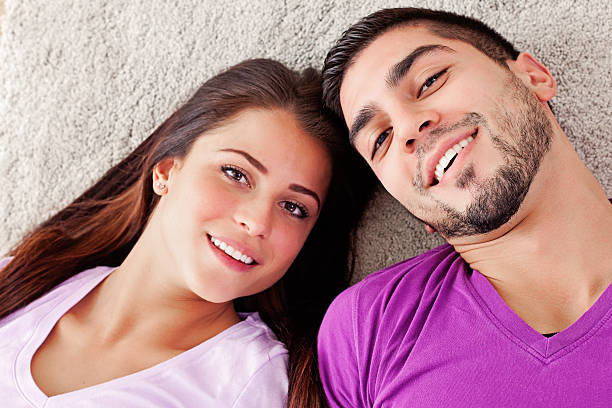 feliz casal jovem - couple loving lying on back carpet imagens e fotografias de stock