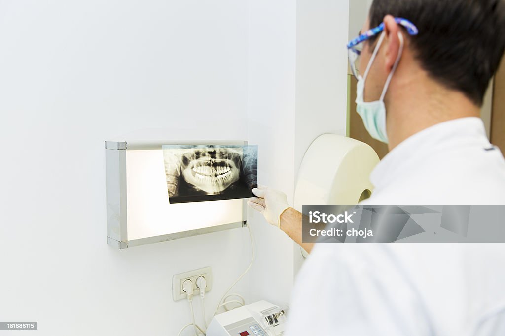 Dentista esaminando una radiografia è di denti - Foto stock royalty-free di Composizione orizzontale