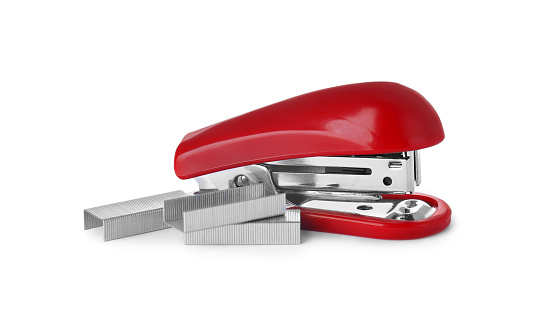 Bright red stapler with staples isolated on white