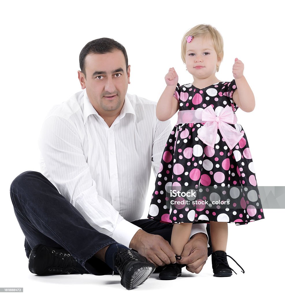 girl with her father little beautiful girl sitting near her father who is tightening the laces. Shoelace Stock Photo