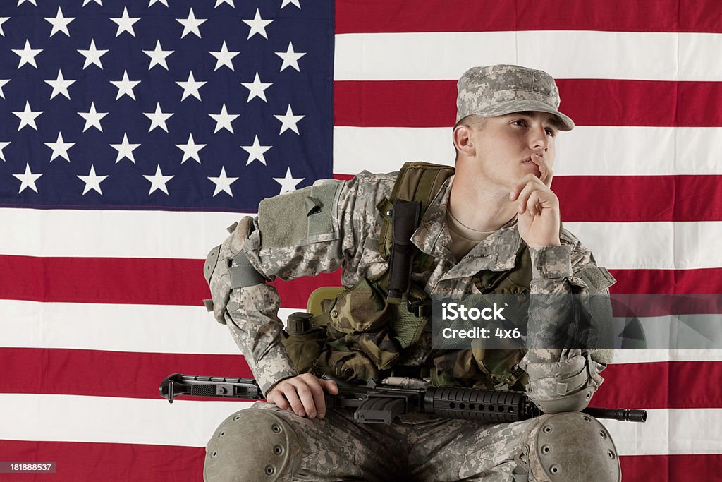 Soldado sentado na frente da bandeira norte-americana - Foto de stock de 20 Anos royalty-free